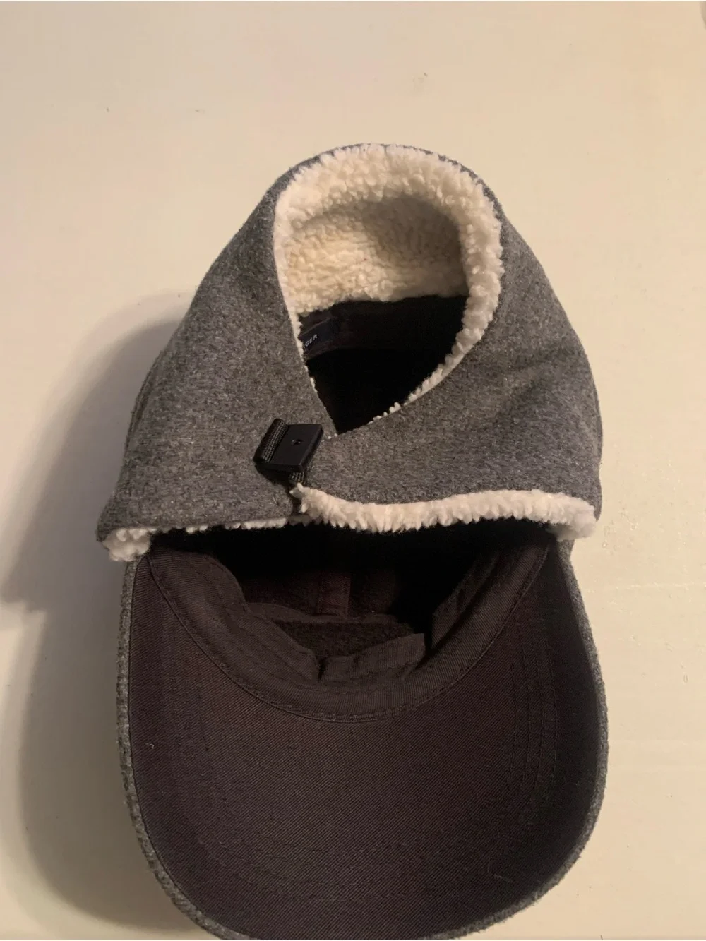 Tommy Hilfiger fleece winter cap featuring fold-down ear flaps with white sherpa